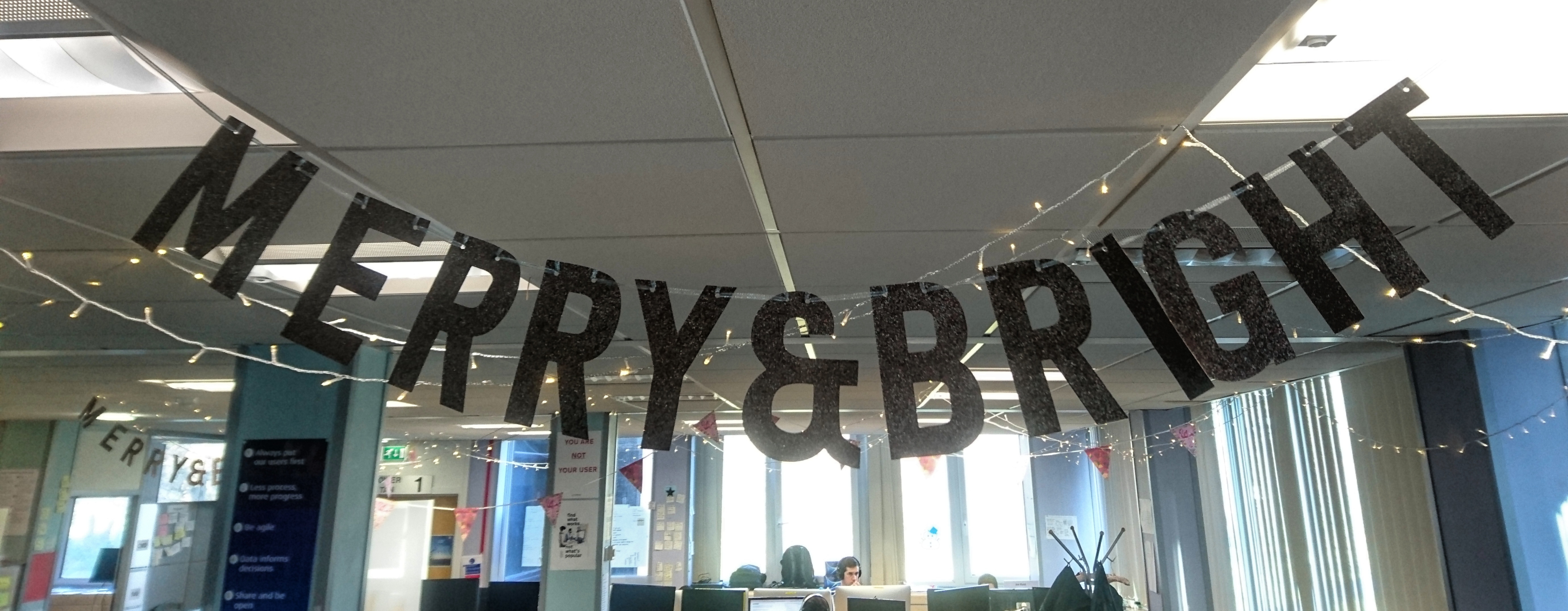 the words merry & bright hanging from the office ceiling